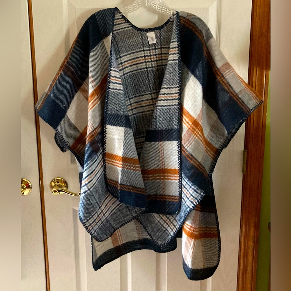 Plaid poncho wrap in gray, black, cream, and rust.